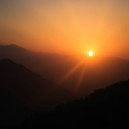 Experience the breathtaking beauty of a moody sunset over a tranquil mountain valley. This stunning image showcases dramatic 