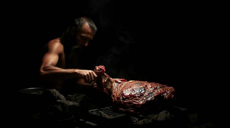 Experience the raw power of the Stone Age with this depiction of a caveman skillfully cooking mammoth meat. The scene is rend