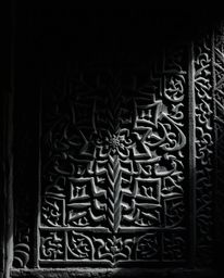 This image showcases the beauty and complexity of Islamic geometric patterns carved in stone.  The intense jet black and chia