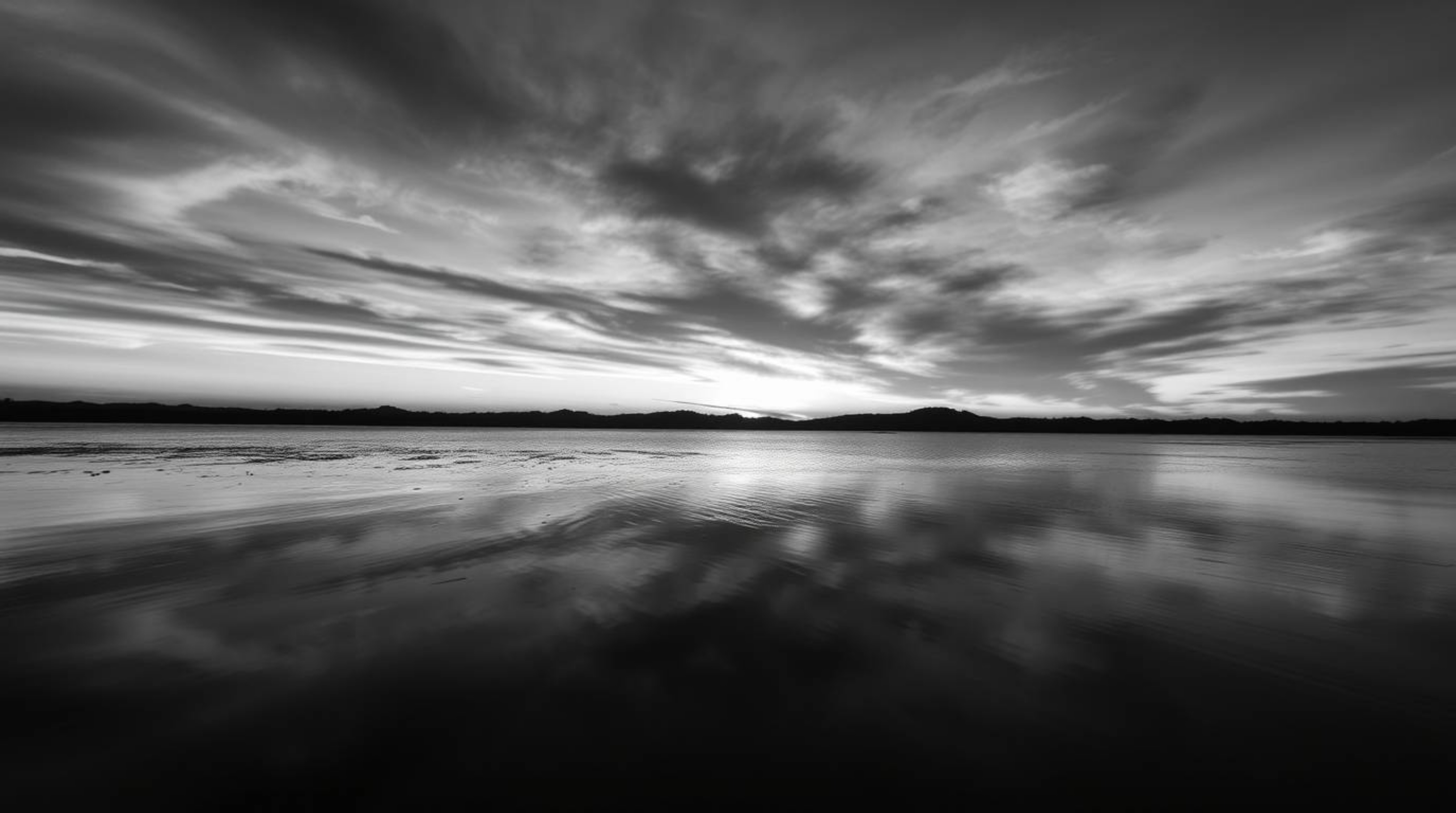 A captivating close-up photograph showcases a serene lake mirroring the vibrant hues of a sunset sky.  The image emphasizes t