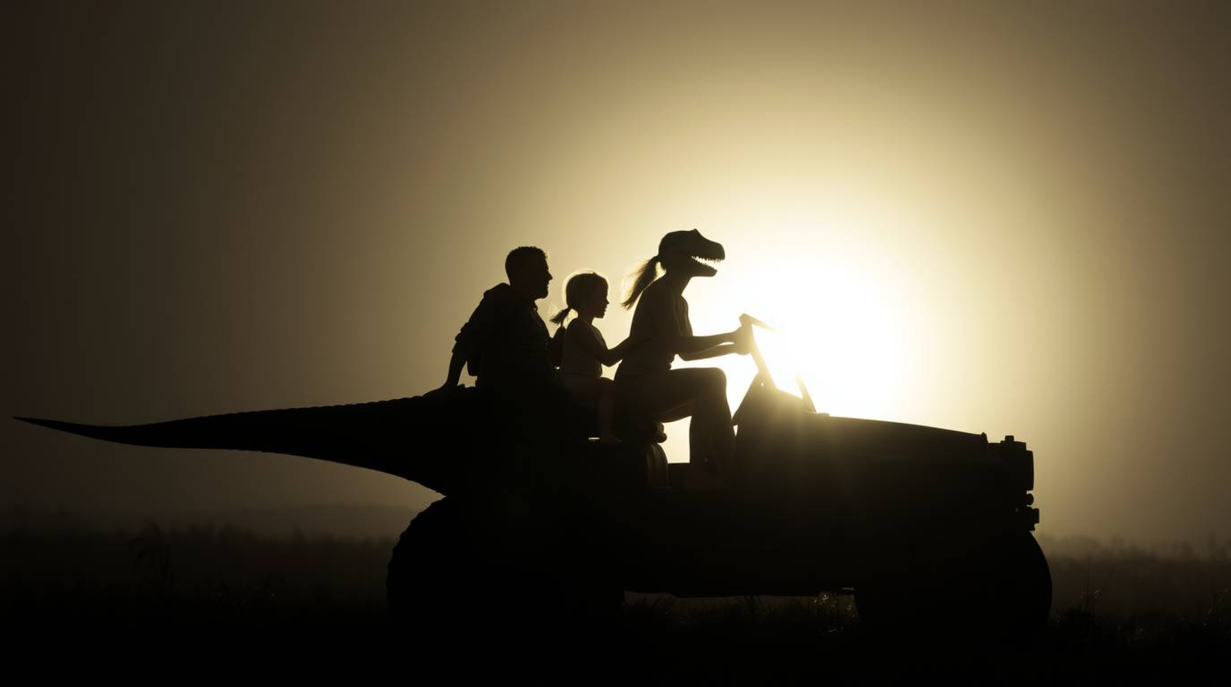 A striking image of a prehistoric family silhouetted against a powerful light source while riding in their dinosaur car. The 