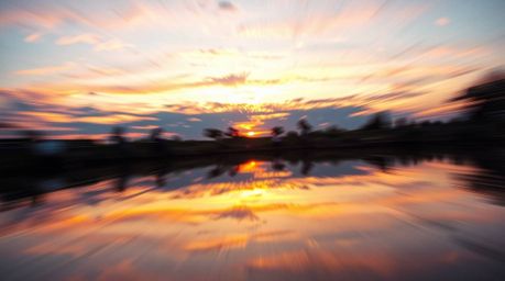 A captivating image showcases a dynamic reflection of a colorful sunset in a tranquil pond.  The artistic depiction utilizes 
