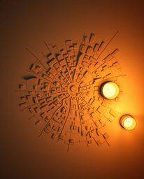 A warm, abstract city map rendered from a bird's-eye view using geometric shapes is bathed in the flickering glow of candleli