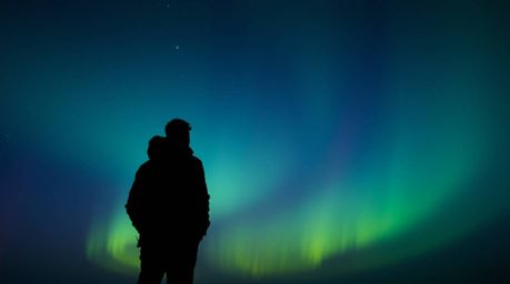 This image features a silhouetted figure captured from a low angle perspective with dramatic backlighting. The gradient text