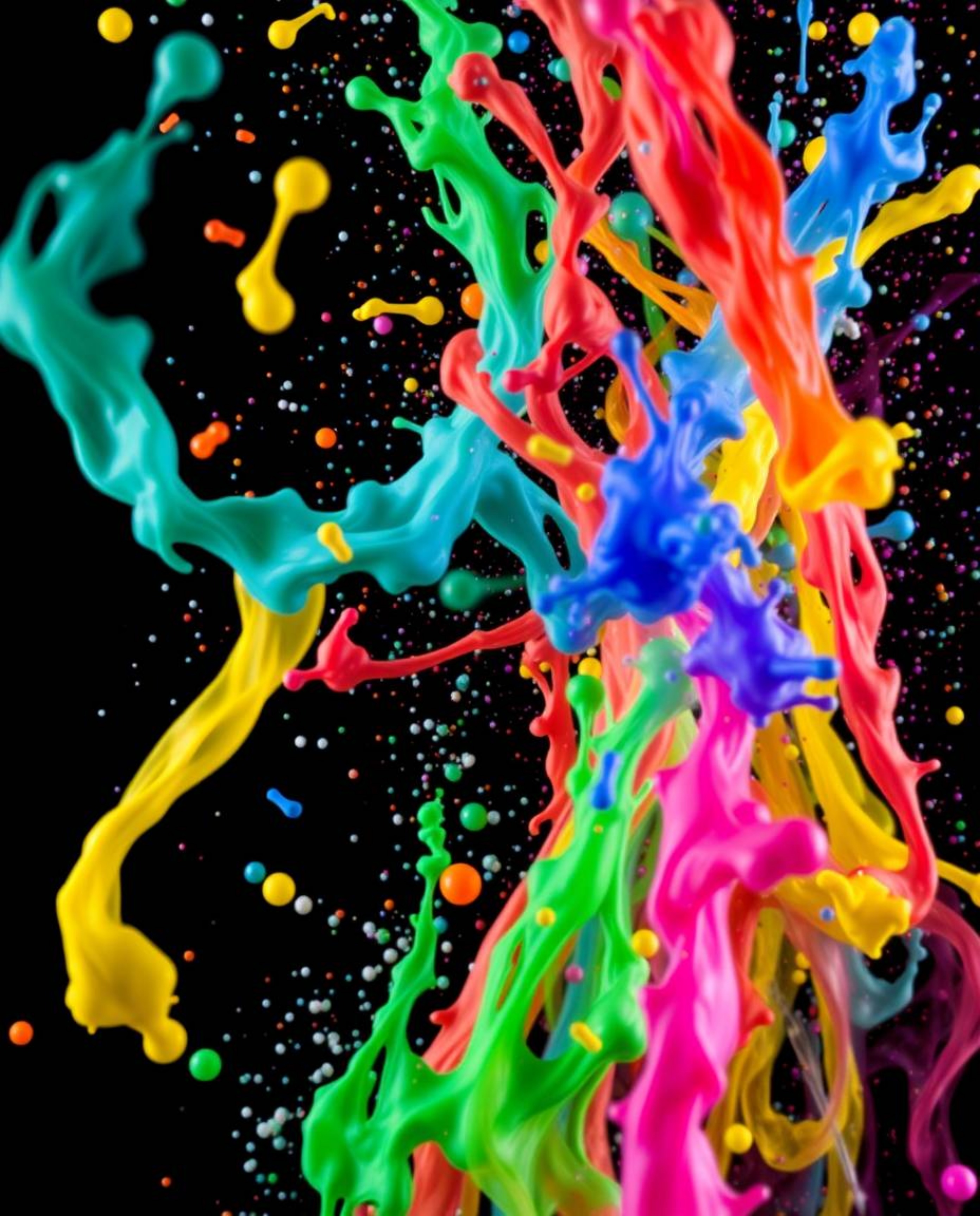 This image captures a vibrant and dynamic scene with colorful splashes dramatically set against a black background.  The free