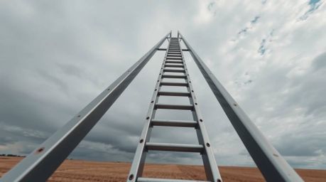 A captivating high-angle architectural photograph depicts a silver ladder standing alone in a vast open field under a dramati