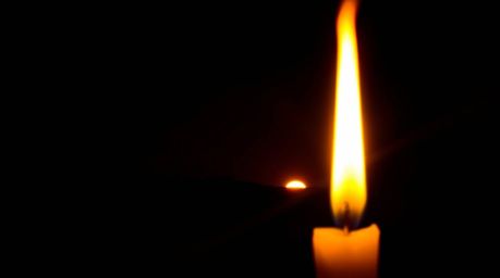 A captivating long exposure photograph showcases the warm glow of candlelight dramatically contrasted against a black backgro
