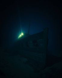 Explore the depths with this captivating high-resolution stock photo of a shipwreck beautifully illuminated deep underwater. 