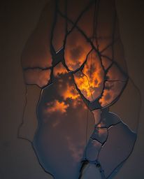 An overhead, bird's-eye view captures a sunset sky mirrored in tidal pools on the beach. This image is rendered in a creative