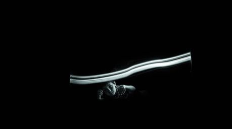 A captivating long exposure photograph depicts a child and a friendly monster under a bed.  The image features high contrast,
