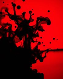 A dramatic, high-contrast macro photograph showcasing vibrant ink splashes in water.  The image features unsettling details a