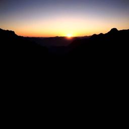 Experience the serene beauty of a jet-black sunset cascading over a tranquil mountain valley.  This image captures the intens