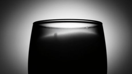 Explore the timeless elegance of silhouetted backlighting with this classic black and white image. A glass object beautifully