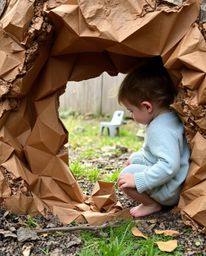 A whimsical illustration depicting a child discovering a magical portal hidden in their backyard. The artwork features natur