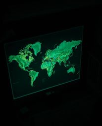 A captivating image showcasing a glowing map projected onto a wall within a dimly lit, old study. The high-angle shot utilize