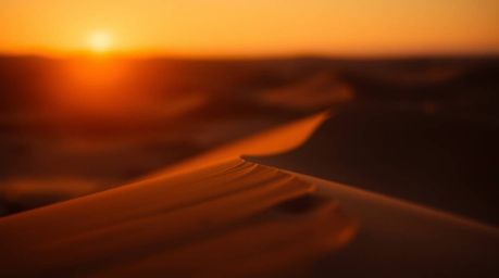Experience the breathtaking beauty of a desert sunset with this stunning image. Featuring high contrast, low-key lighting, an
