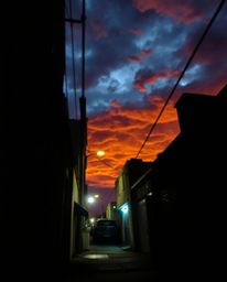 A candid street photography shot captured the intense drama of eyes watching from a shadowed alley at night. The spontaneous 