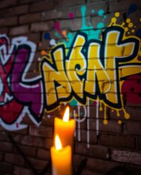 A captivating long exposure photograph showcases vibrant graffiti-style splashes on a brick wall, dramatically illuminated by