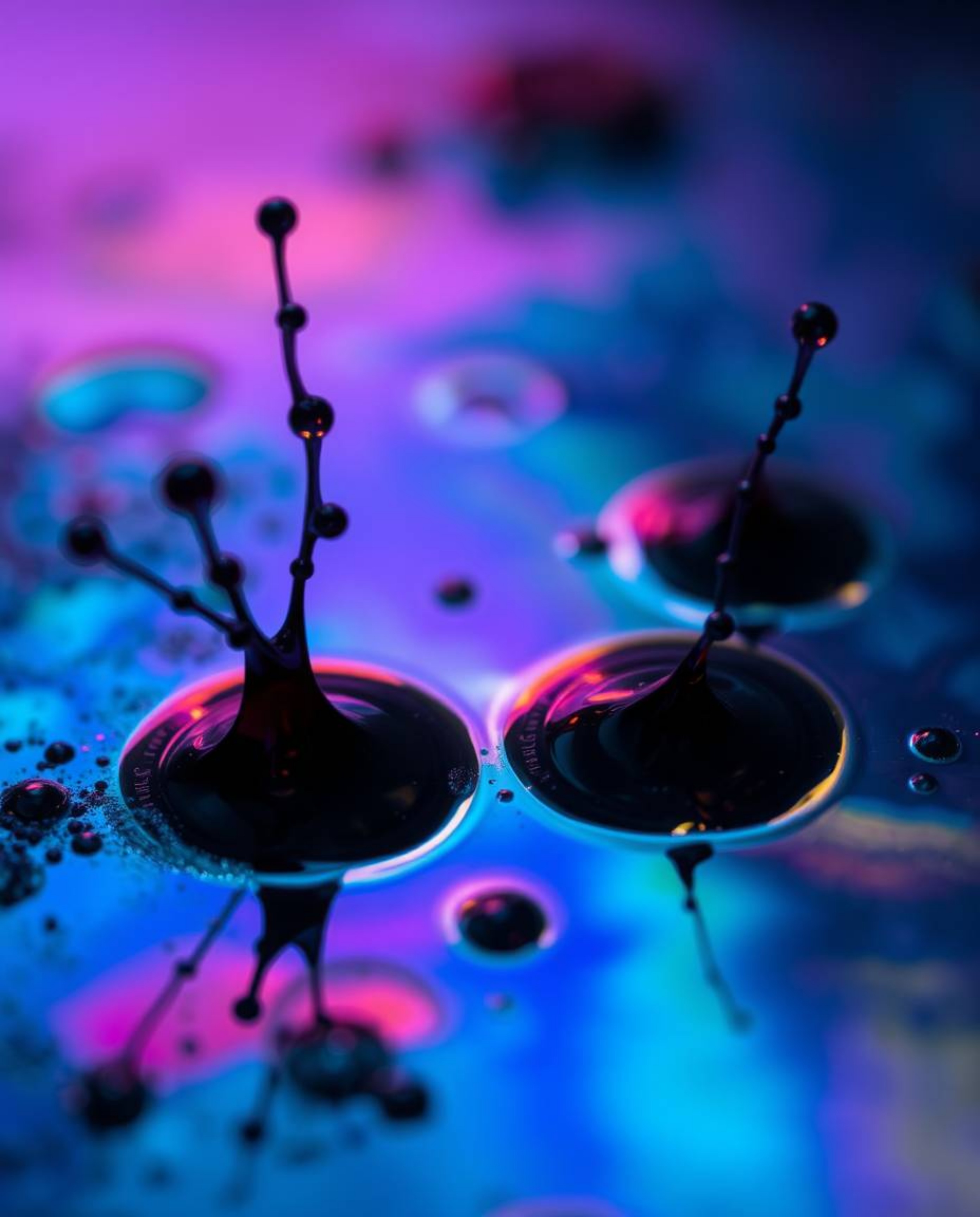 Explore the mesmerizing world of dark-toned ink splashes in water, brought to life with iridescent colors and captured in stu