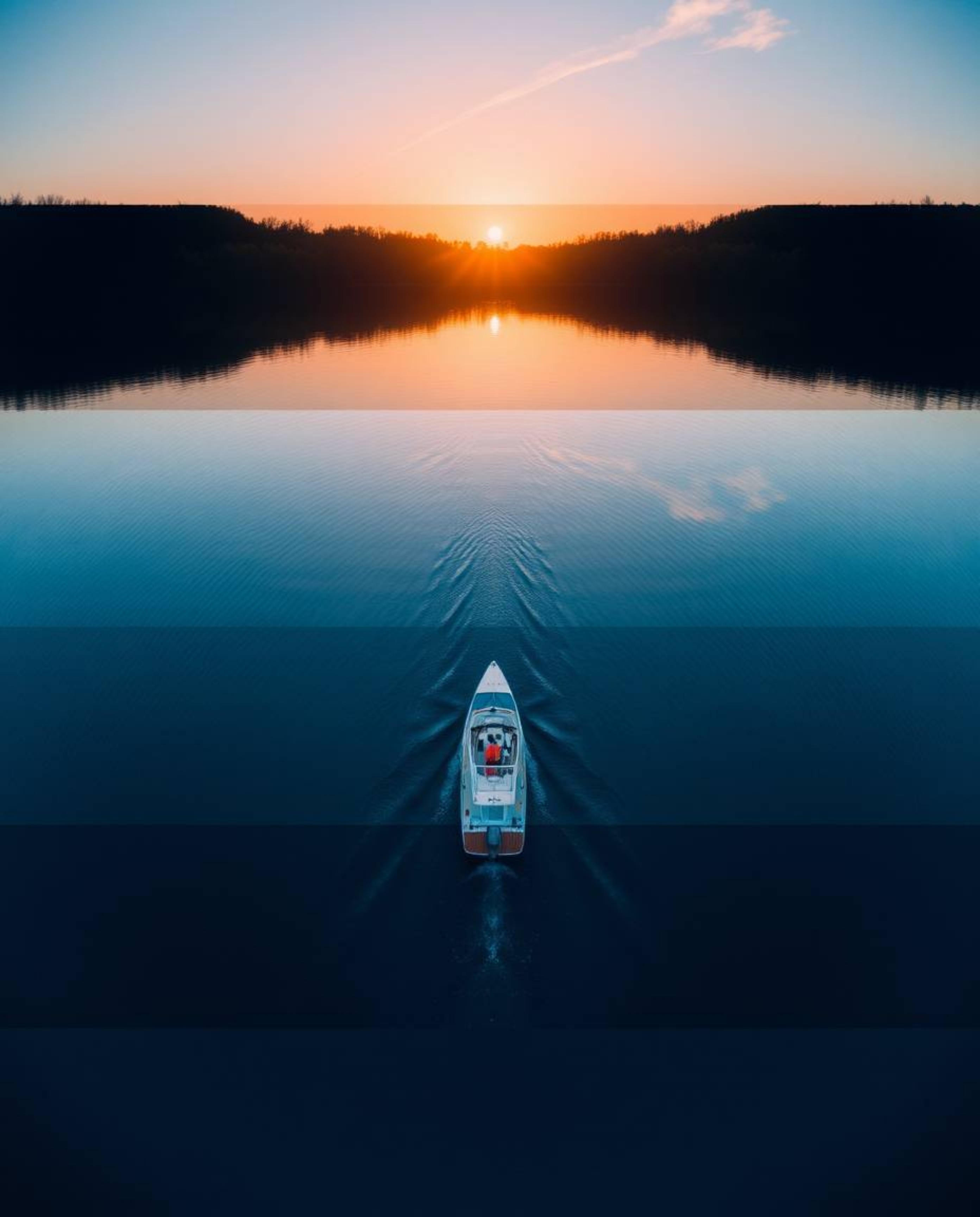 A bird’s-eye view photograph depicts a boat drifting on a lake at sunset. The composition is uniquely split into distinct ove
