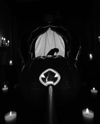 A captivating high-angle shot depicts a magical pumpkin transforming into a classic carriage, rendered in timeless black and 