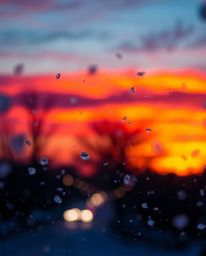A surreal and captivating image of snowflakes falling during a vibrant sunset, enhanced by a beautiful blurred bokeh effect. 