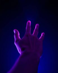 Explore the mesmerizing world of long exposure photography with a captivating image of a hand reaching towards light from dar