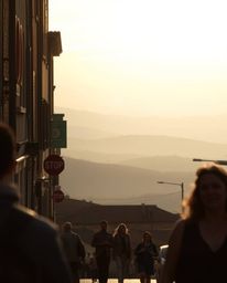 This is a unique image capturing a sunset over misty rolling hills in Tuscany through the lens of candid street photography. 