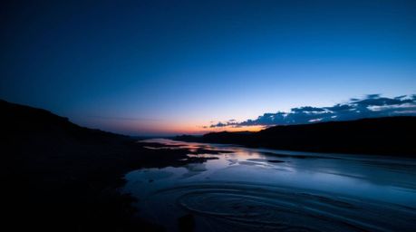 Experience the breathtaking beauty of a river delta bathed in the enchanting glow of twilight. This stunning low-angle perspe