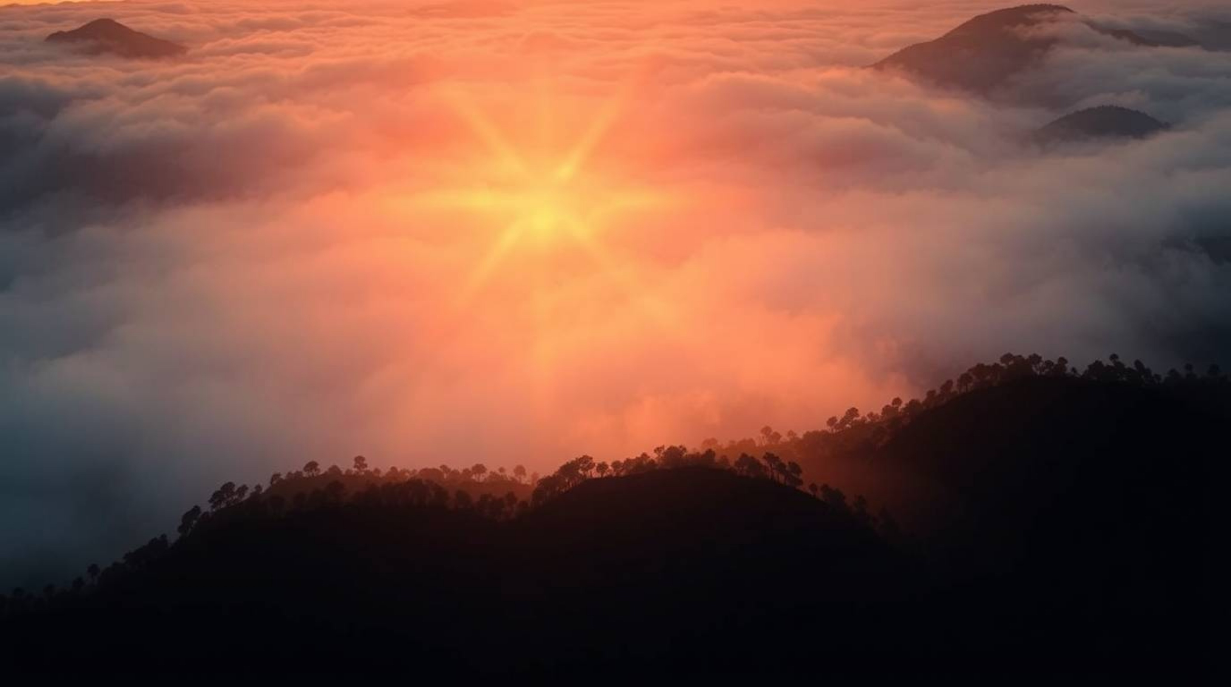 This captivating scene features a high-contrast low-key illustration, showcasing fog-covered hills bathed in the warm glow of
