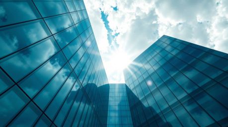 This striking image showcases a modern glass building that appears to seamlessly dissolve into a soft, cloudy sky, creating a