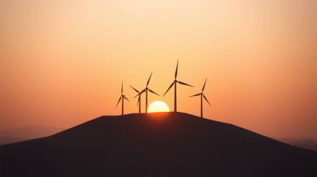 Experience the serene beauty of a sunset behind wind turbines, captured in an intricate origami style with a soft cinematic h