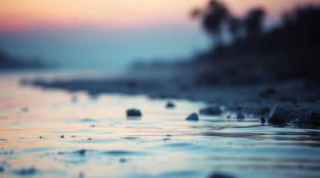 A captivating close-up reveals a river delta bathed in the soft, glowing hues of twilight.  The cinematic haze and shallow de