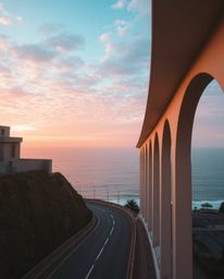 This precise architectural color photograph captures a sunset sky over a winding coastal highway, imbued with an ethereal and