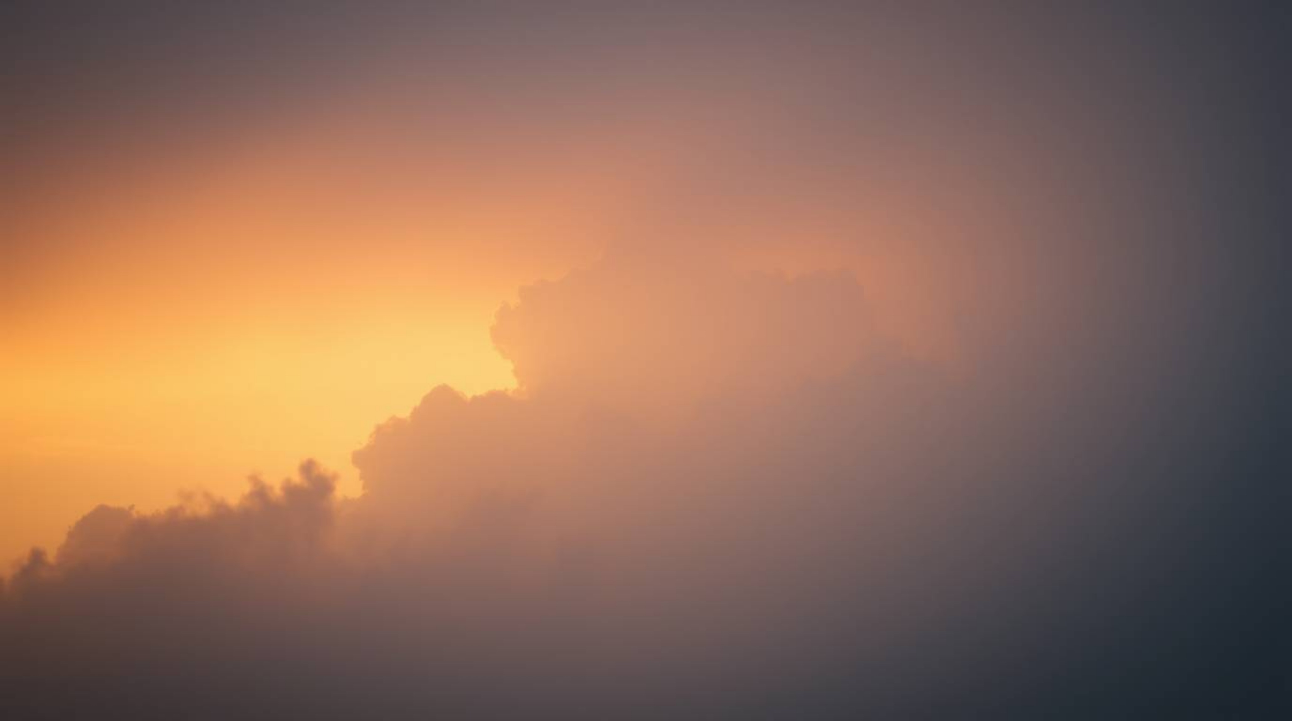 Capture the ethereal beauty of a soft, dreamy sunset thunderstorm.  Hazy light illuminates dramatic clouds, creating a captiv