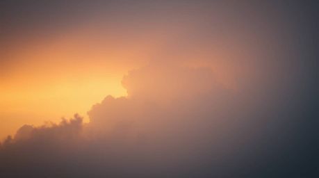 Capture the ethereal beauty of a soft, dreamy sunset thunderstorm.  Hazy light illuminates dramatic clouds, creating a captiv