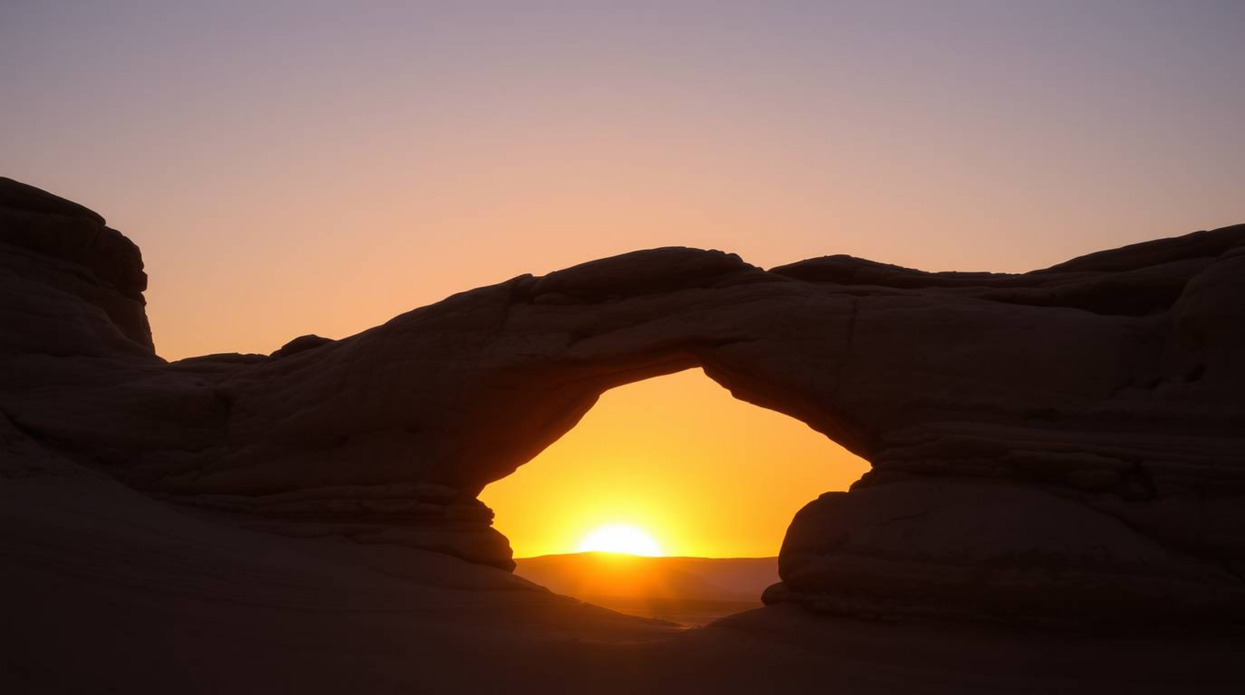Experience the breathtaking beauty of a desert sunset captured through a natural rock arch in this high-resolution stock phot