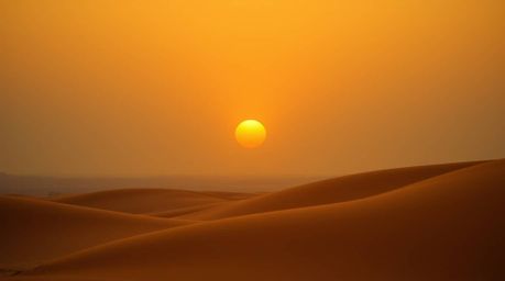 A breathtaking cinematic image captures a vibrant sunset over golden desert dunes.  Deep teal and golden hues create a luxuri