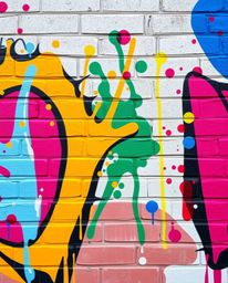 Experience the dynamic energy of vibrant, complementary colors splashed across a brick wall in this captivating street art sc