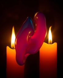 This mesmerizing long exposure photograph captures the dance between warm candlelight and vibrant, split 3D fluid shapes inte