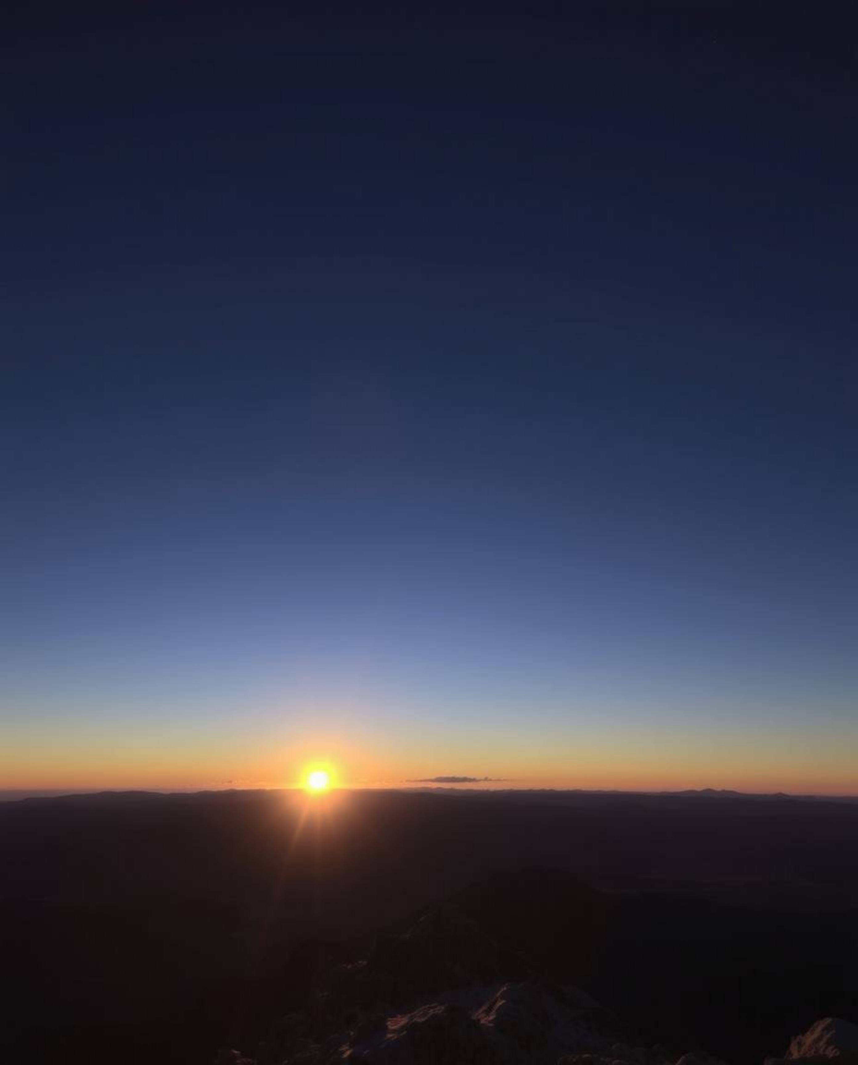 This is a high-resolution stock photo capturing a breathtaking sunset as viewed from a high alpine peak. With its professiona