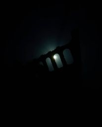 A silhouetted shipwreck, beautifully illuminated deep underwater, creates a captivating scene. The backlighting effect emphas