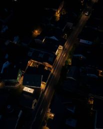 This stunning image captures a sleepy town with pastel-colored houses from a bird's-eye view, enhanced by intense dramatic li