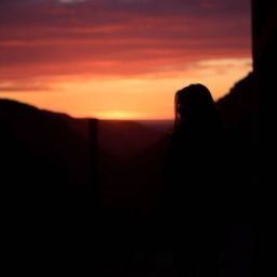 A sophisticated and elegant candid street photograph captures a breathtaking sunset over a quiet mountain valley, rendered in