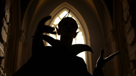 This image captures a classic Disney villain, silhouetted and with sharp features, against the backdrop of an old castle. The
